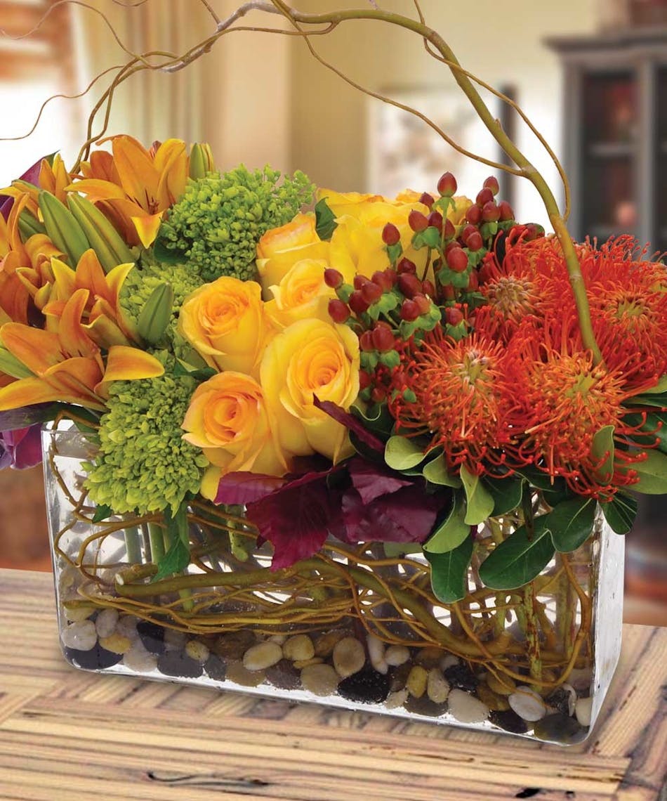 Modern vase of unique flowers including roses, lilies and hydrangeas.