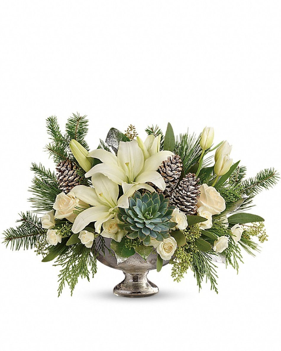 Holiday centerpiece of green and white flowers, succulents and more in a mercury glass bowl.